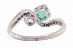 EDWARDIAN DIAMOND AND EMERALD CROSS-OVER RING, CIRCA 1910