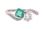 EDWARDIAN DIAMOND AND EMERALD CROSS-OVER RING, CIRCA 1910