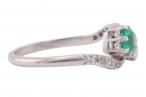 EDWARDIAN DIAMOND AND EMERALD CROSS-OVER RING, CIRCA 1910