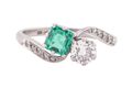 EDWARDIAN DIAMOND AND EMERALD CROSS-OVER RING, CIRCA 1910