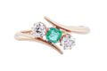 EDWARDIAN EMERALD AND DIAMOND THREE-STONE CROSSOVER RING, 1909