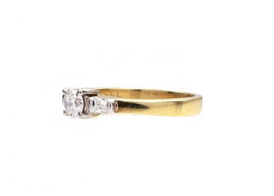 Flanked diamond solitaire engagement ring in 18kt yellow gold