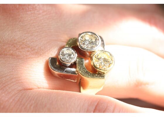 Vintage three-stone diamond monochromatic cocktail ring featuring a crossover design, circa 1960