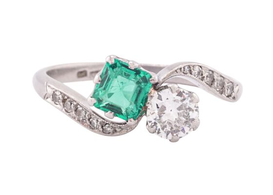 EDWARDIAN DIAMOND AND EMERALD CROSS-OVER RING, CIRCA 1910