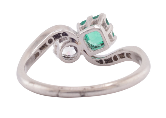EDWARDIAN DIAMOND AND EMERALD CROSS-OVER RING, CIRCA 1910
