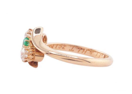 EDWARDIAN EMERALD AND DIAMOND THREE-STONE CROSSOVER RING, 1909
